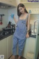 a woman standing in a kitchen holding a cup of coffee